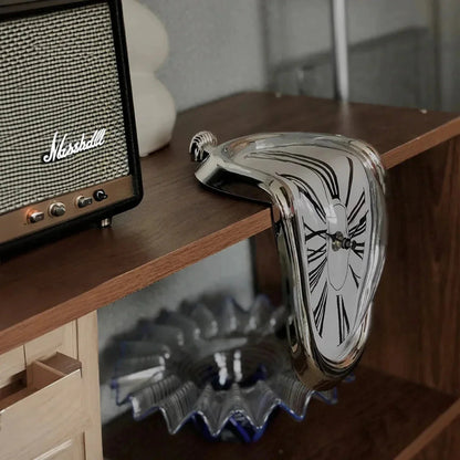 Surreal melting clock with roman numerals on wooden shelf next to vintage speaker